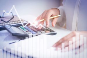 Contabilidade para empresas do Lucro Real - contadora especializada no regime do Lucro Real fazendo apuração de impostos usando uma calculadora