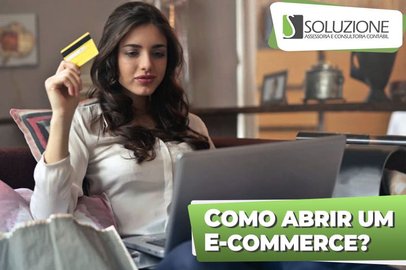 Como abrir um ecommerce - imagem de mulher feliz com notebook e cartão de crédtio fazendo compra em loja virtual