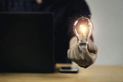 Consultoria Contábil - imagem de consultor contábil com lâmpada acesa na mão, simulando uma ideia para o negócio do cliente